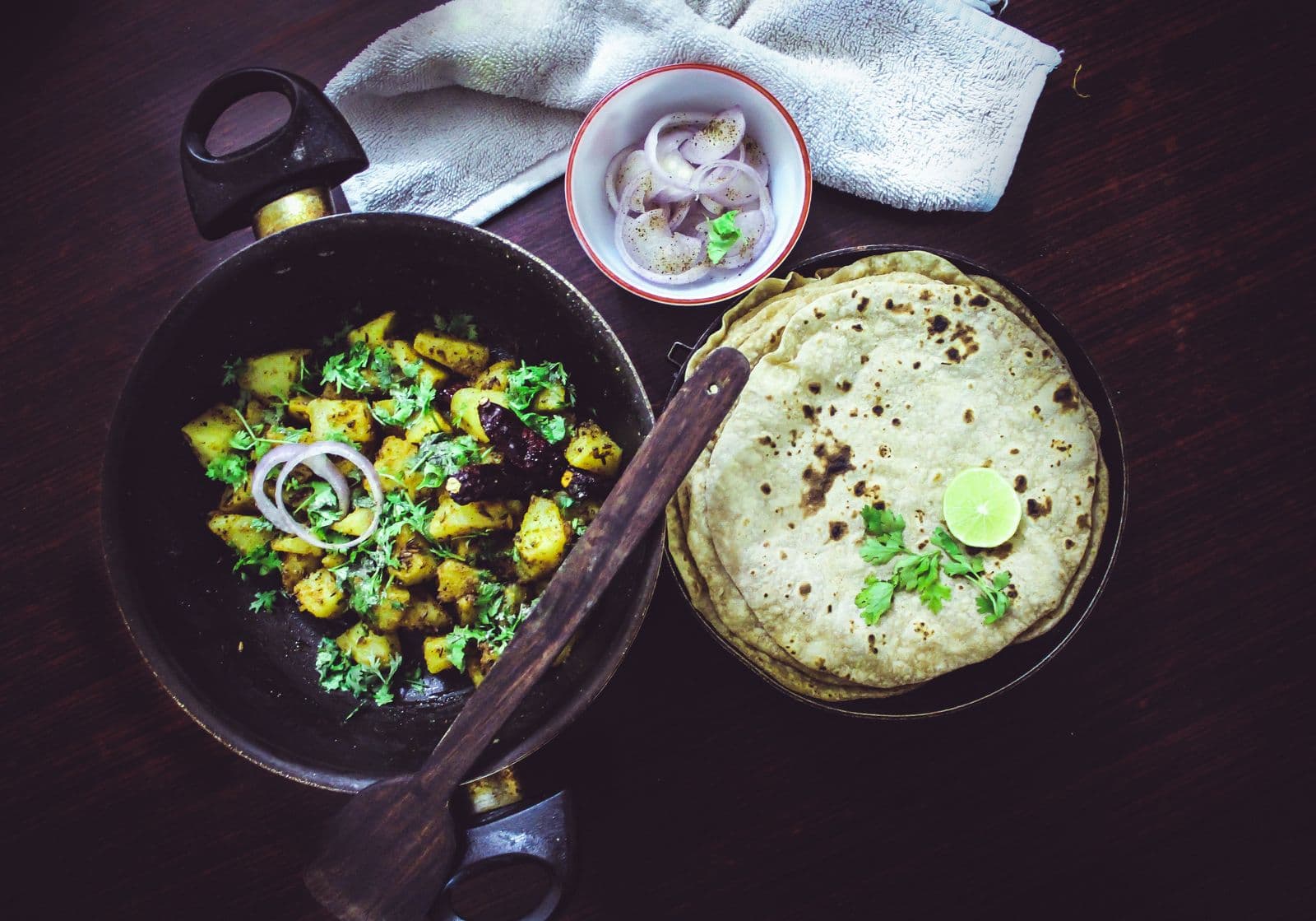Aloo fry beside a stack of warm rotis